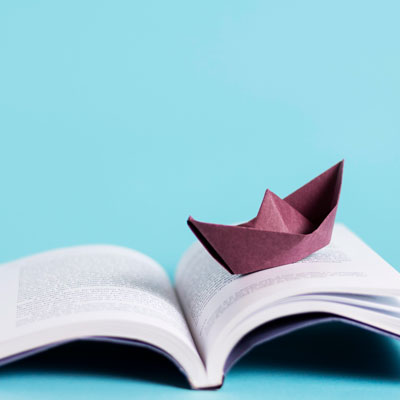 A book with a paper boat on it