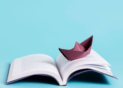 A book with a paper boat on it