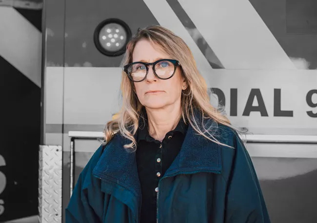 A paramedic standing infront of an ambulance