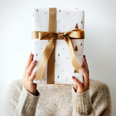 A woman with a gift covering her face.