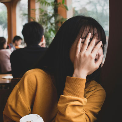 A girl covering her face with her hands